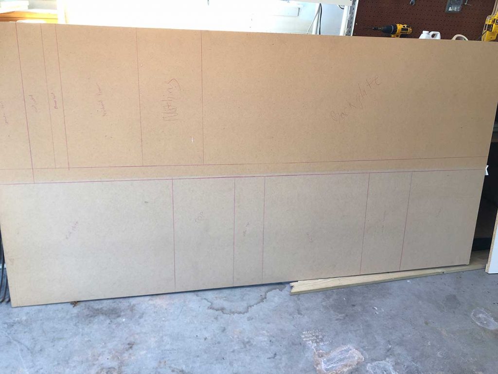 Early cabinet shell pieces laid out during the garage arcade build